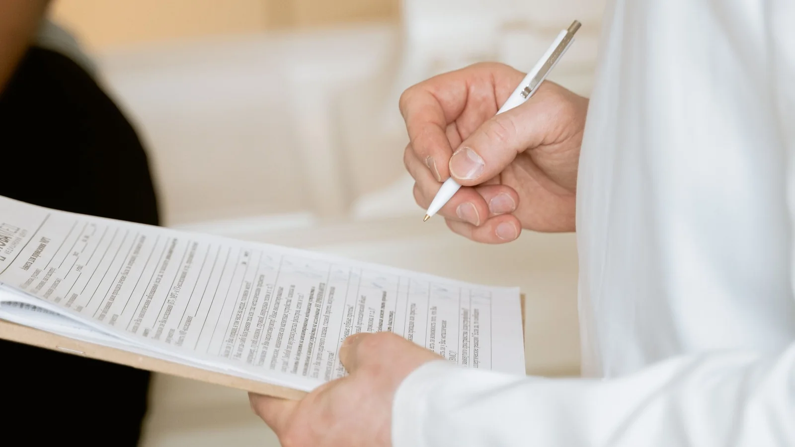 Medical professional reviewing documents on a clipboard