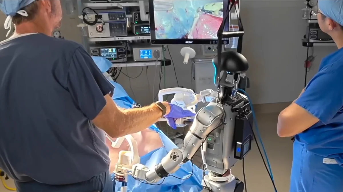 Clinicians working beside a humanoid robot during a preclinical surgical procedure.