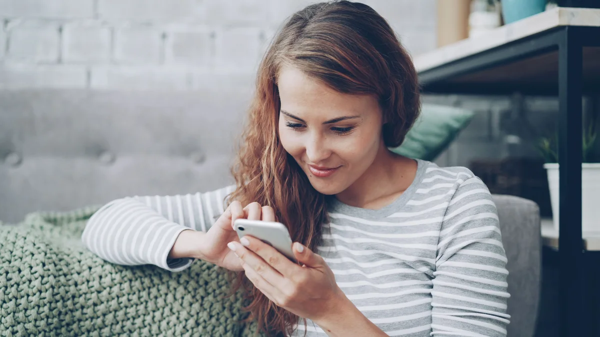 Person at home using a smartphone, representing consumer-facing medical AI and everyday health-information use